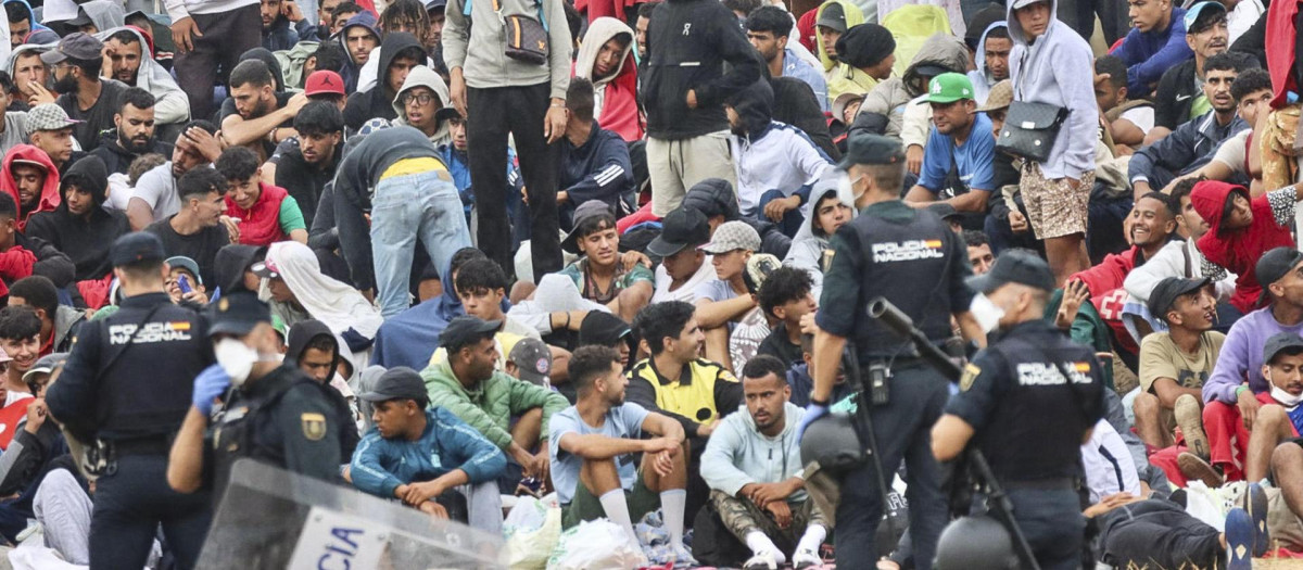 Un grupo de policías custodiando a un grupo de inmigrantes ilegales en Ceuta
