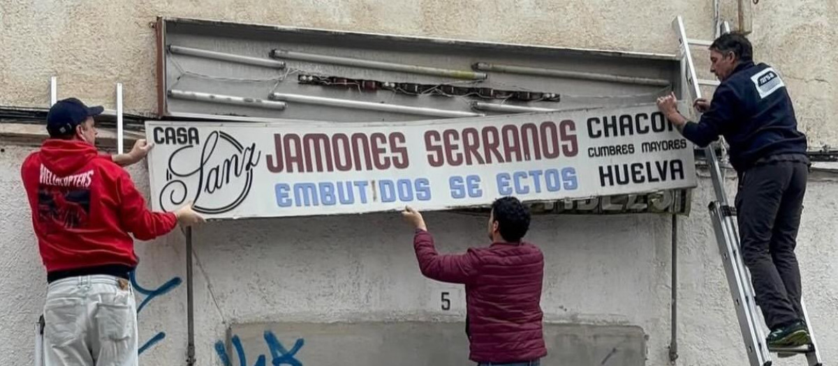 Miembros de Patrimonio Gráfico Sabadell desmontando un cartel