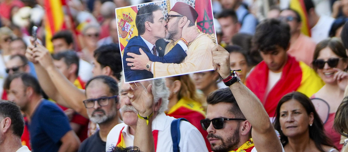 Un ciudadano sostiene un fotomontaje de Sánchez besando a Mohamed VI en la concentración de Madrid