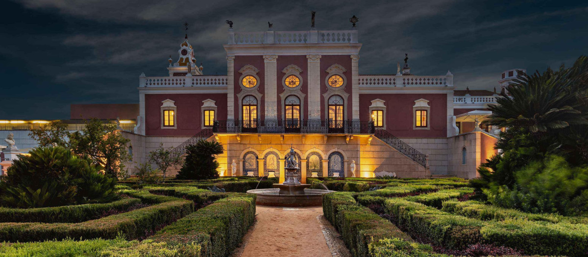 Fachada iluminada de noche de la Pousada Palacio Estoi