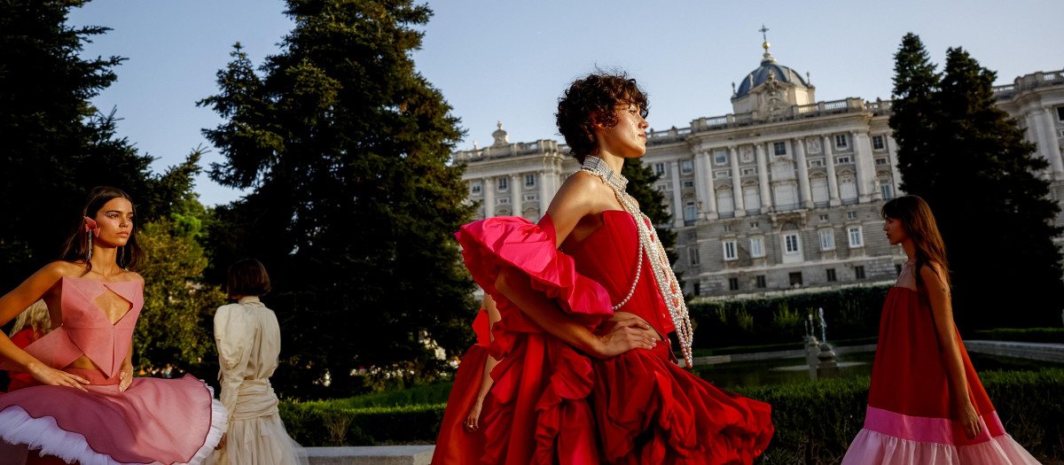 Varias modelos desfilan junto al estanque central de los Jardines de Sabatini durante el inicio este lunes de la semana de la moda de autor española ´OMODA Madrid es Moda´. EFE / Daniel González.