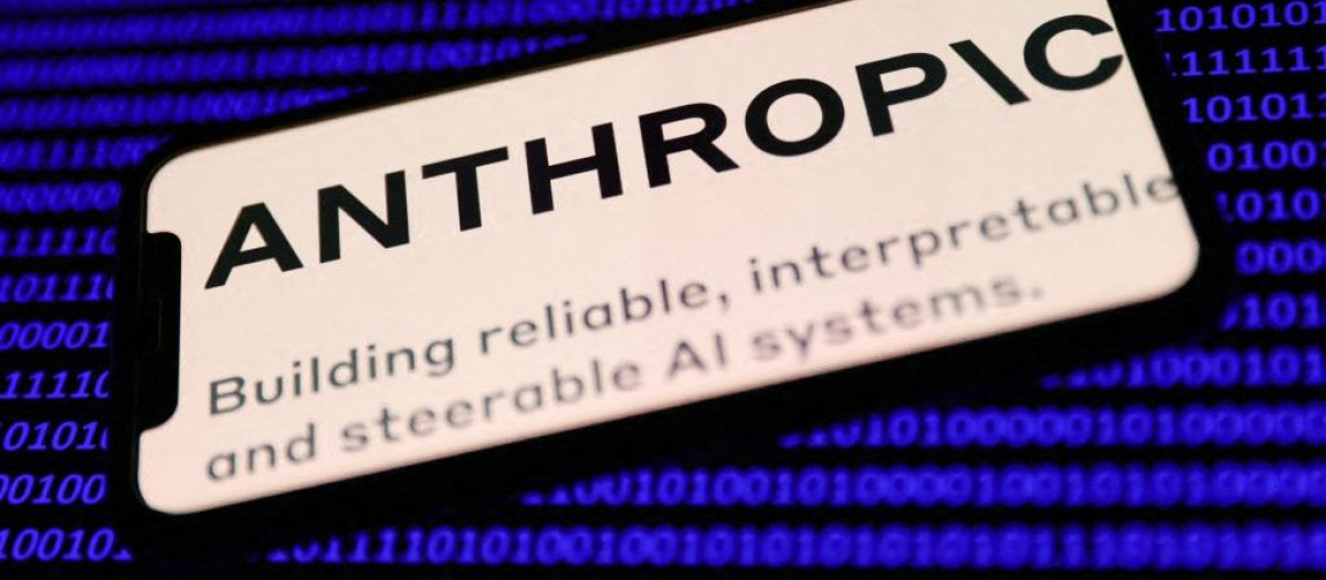 El logotipo de Anthropic en la pantalla de un teléfono y código binario en la pantalla de un ordenador portátil