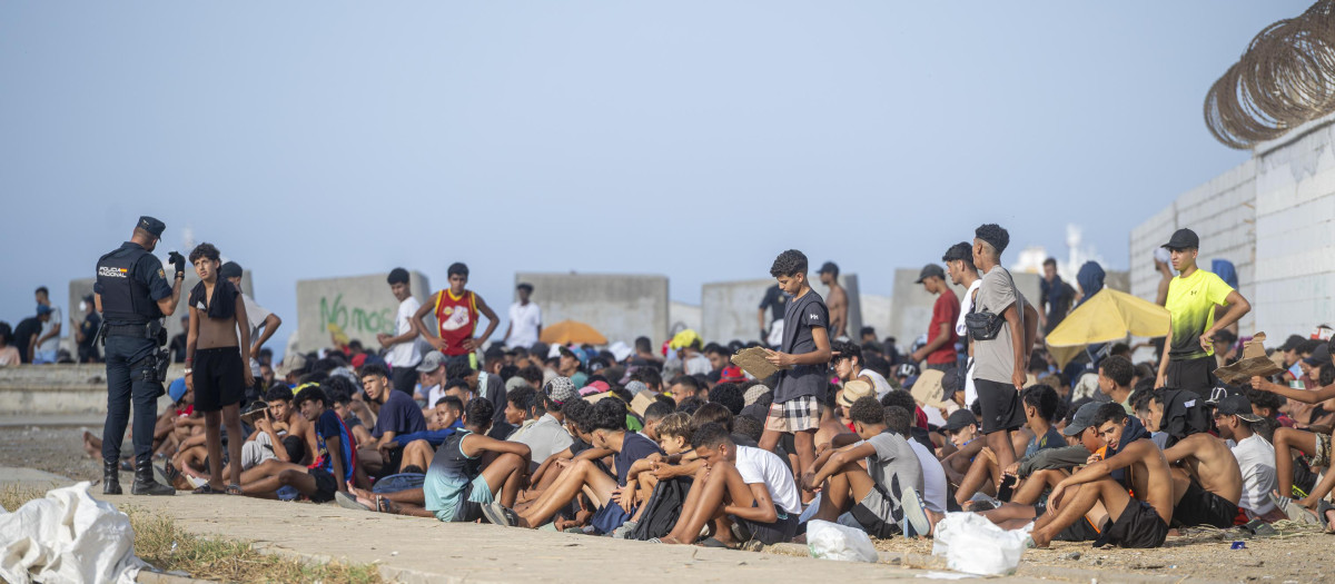 Decenas de inmigrantes en la playa de El Trampolín, a 7 de septiembre de 2026, en Ceuta