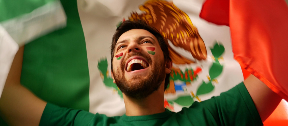 Un hombre enarbola la bandera de México