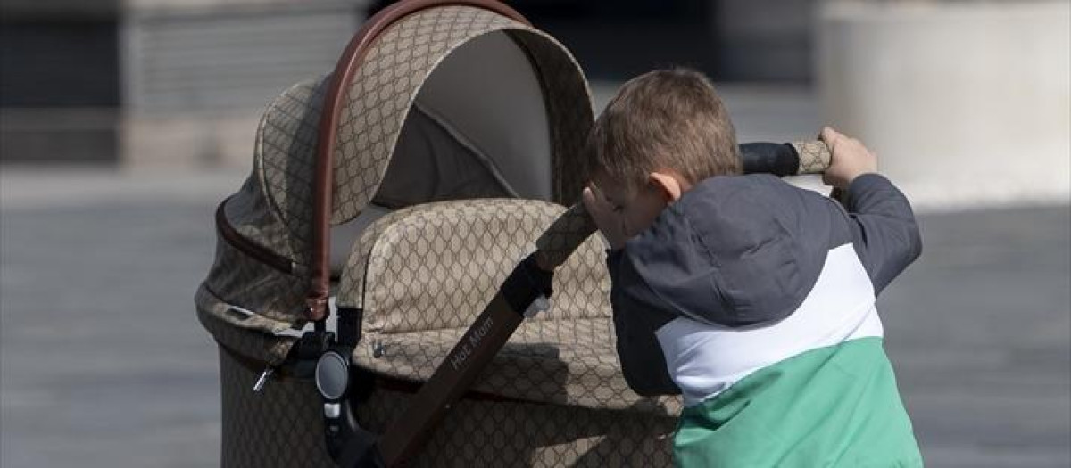 Un niño con un carro de un bebé en Pozuelo de Alarcón, Madrid