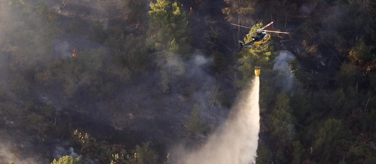 Un helicóptero colabora en las labores de extinción de un incendio forestal