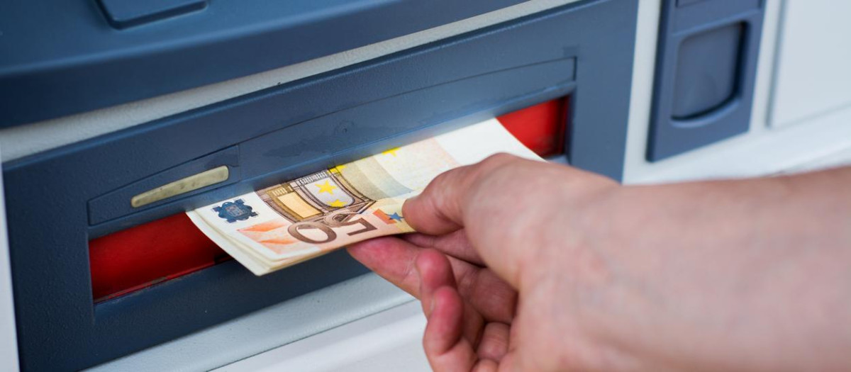 Una persona sacando dinero de un cajero
