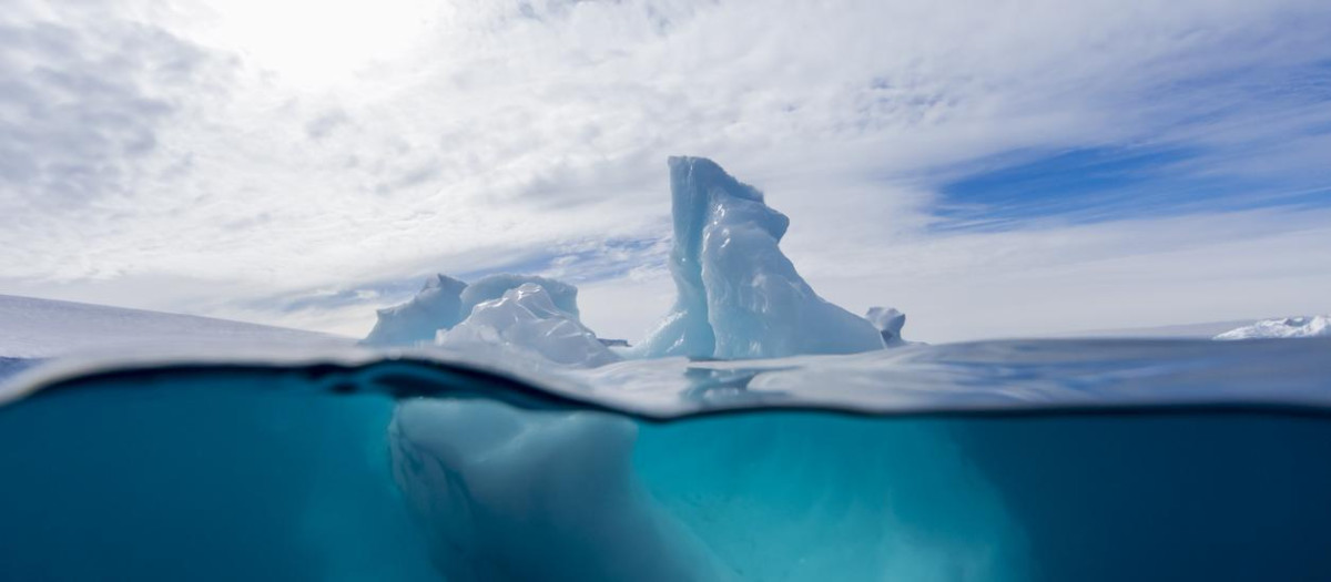 Vista bajo y sobre el agua de un iceberg