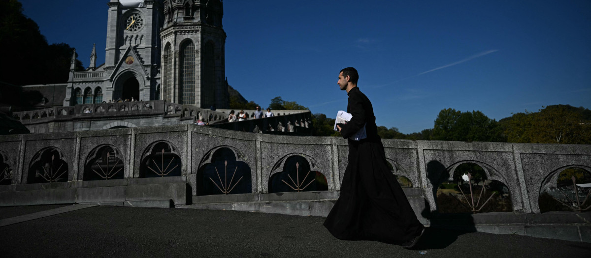 Un sacerdote pasa junto a la Basílica de Notre-Dame du Rosaire cinco días antes de la visita del papa León XIV a este lugar