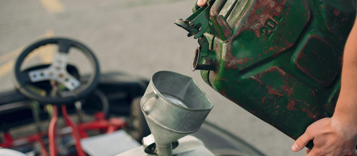 Un agricultor rellena el depósito de su tractor con gasóleo agrícola