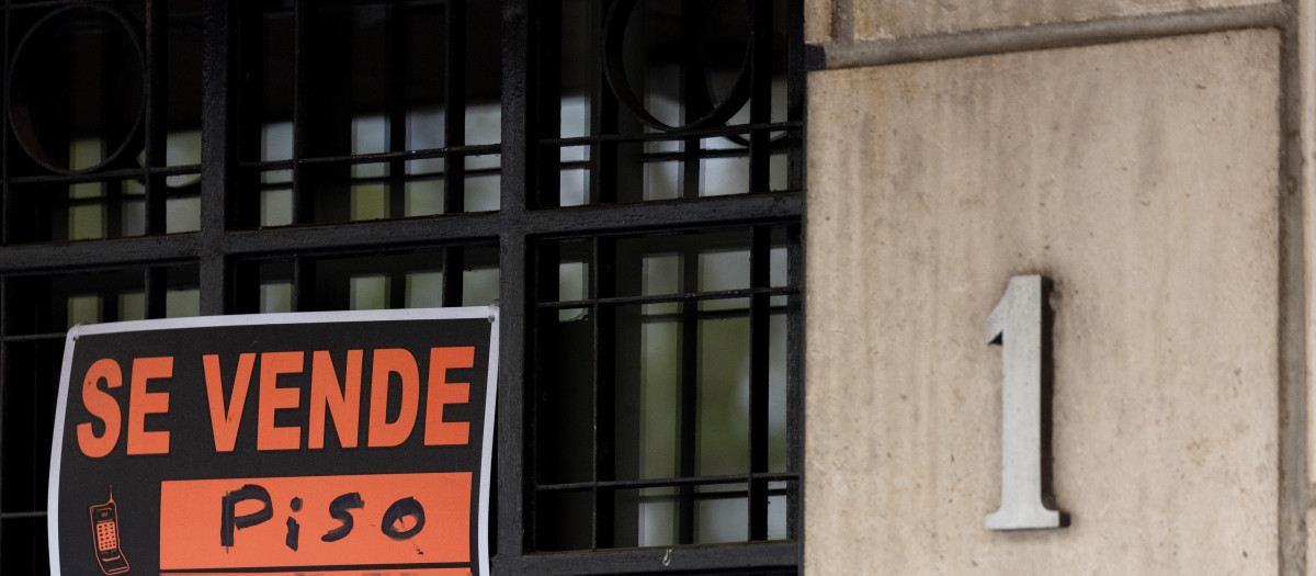Vista de un cartel de 'Se vende' en un portal de un edificio