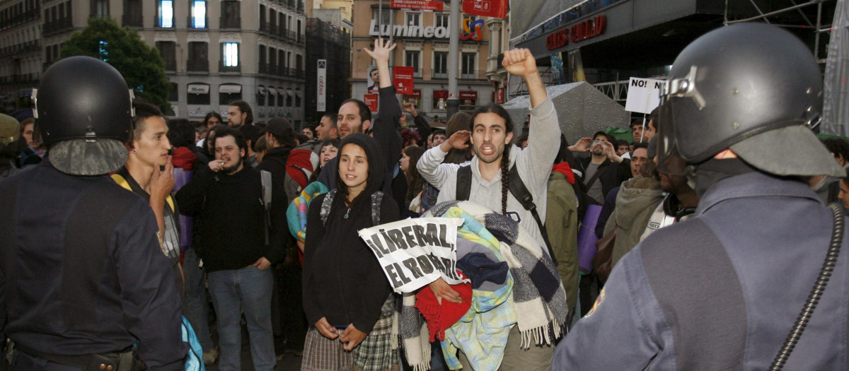 Agentes de la Policía Nacional frente a unos manifestantes del 15-M en la Puerta del Sol el 17 de mayo de 2011