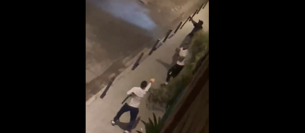 Uno de los delincuentes, abajo, apunta a los dos agentes mientras porta una escopeta