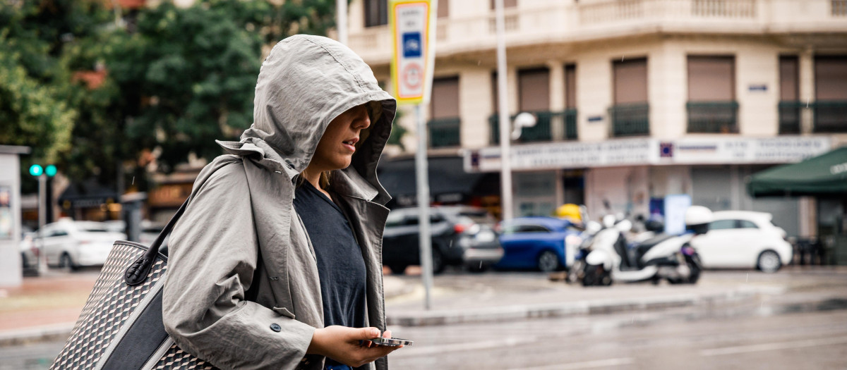 Una mujer pasea bajo la lluvia en Madrid