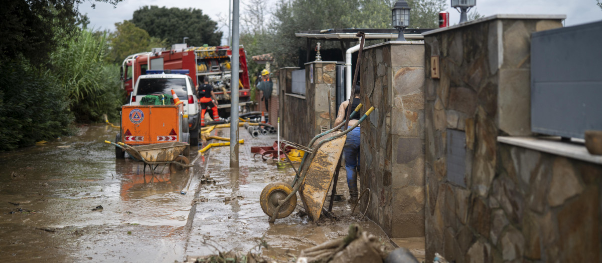Calle y vehículos cubiertos de barro a causa de las lluvias torrenciales
