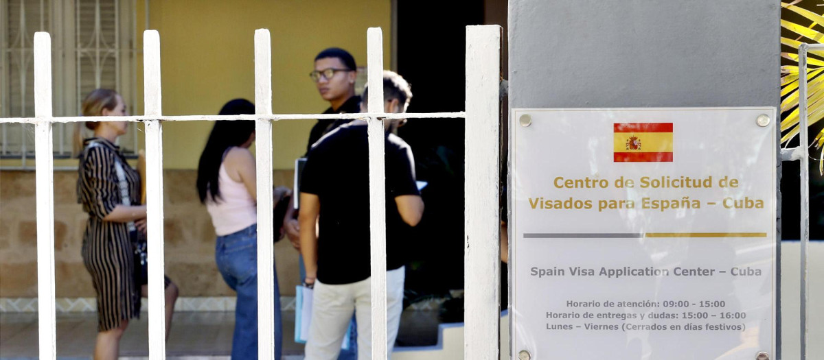 Personas hacen fila para entrar a las nuevas oficinas del consulado de España en La Habana