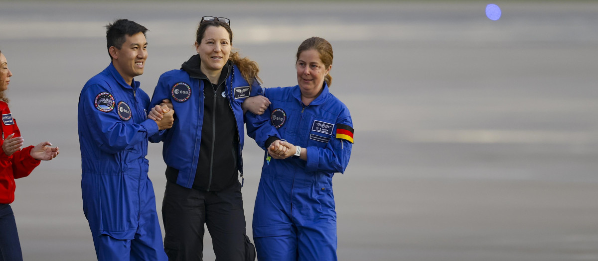 La astronauta de la Agencia Espacial Europea (ESA) Sophie Adenot (centro), de Francia, desciende de un avión a su llegada a la zona militar del aeropuerto de Colonia-Bonn, Alemania