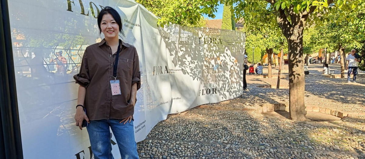 Sohee Park en el Patio de los Naranjos, junto a las lonas que protegen su obra