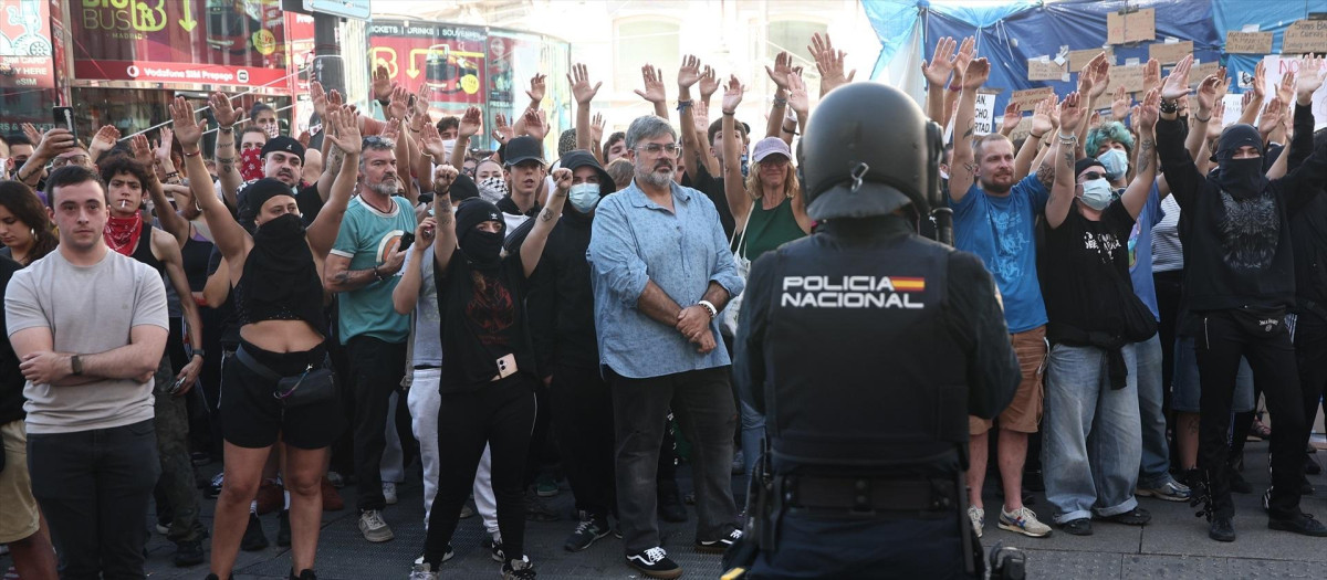 Los acampados por la vivienda hacen una cadena humana contra las personas que se han juntado para protestar contra ellos en la Puerta del Sol