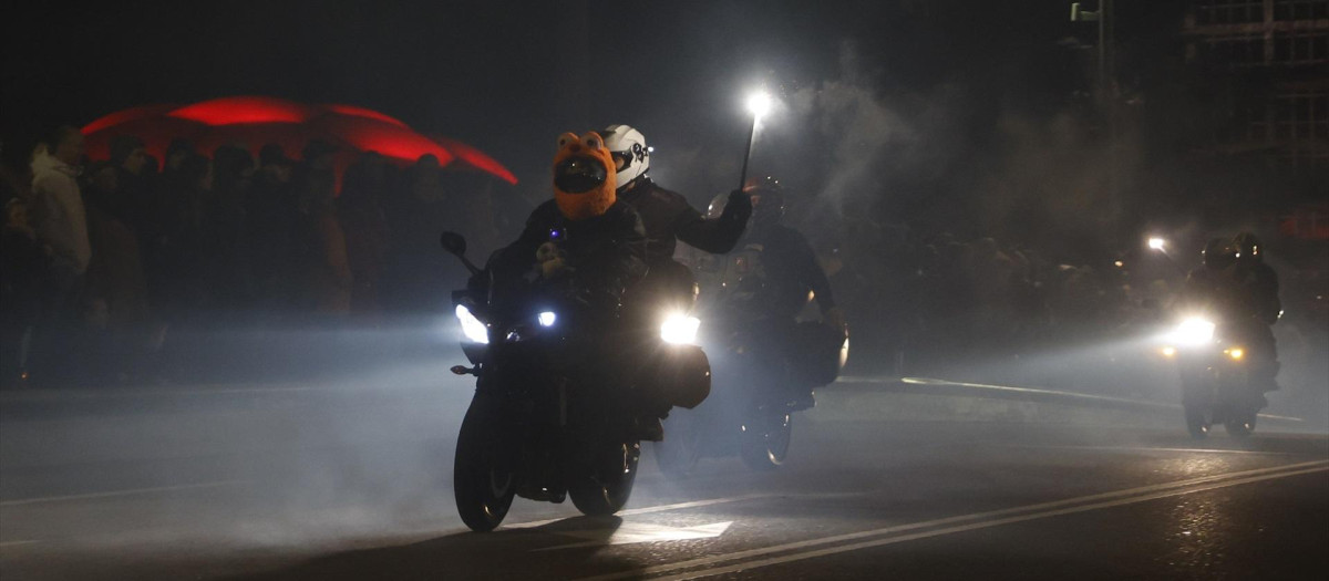 Varios motoristas participan con sus motos en el desfile de las antorchas en la concentración motera Pingüinos