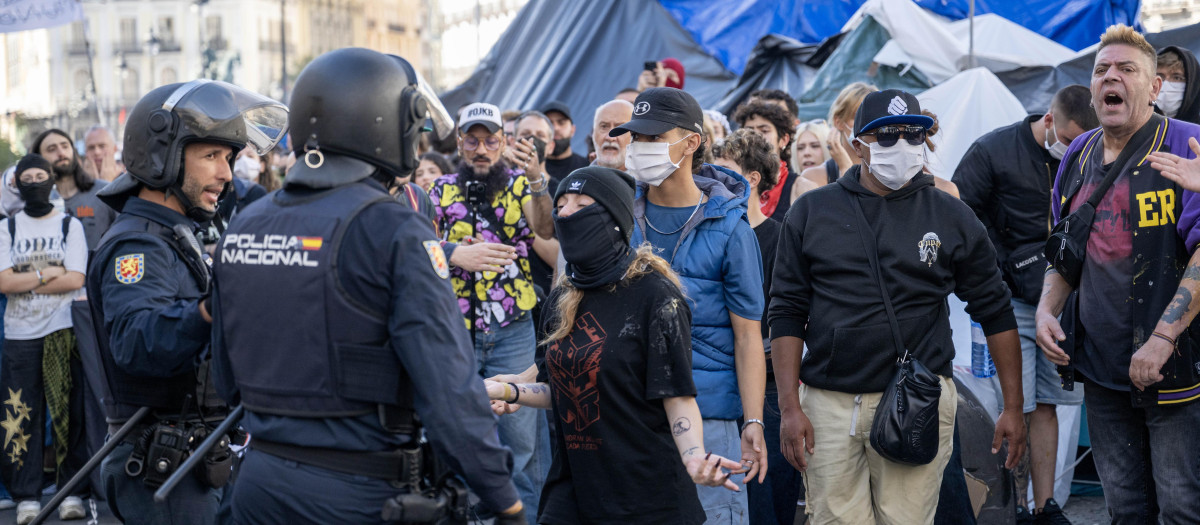 Policía antidisturbios mediando entre los acampados en la Puerta del Sol durante una protesta en el centro de la ciudad
