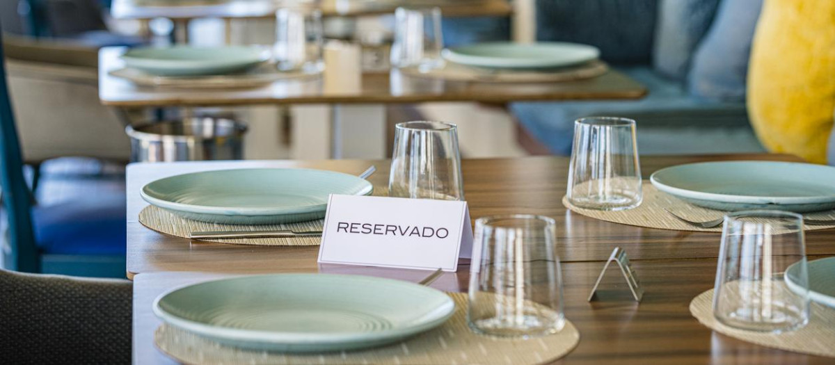 Restaurante con varias mesas reservadas para cenar a plena luz del día