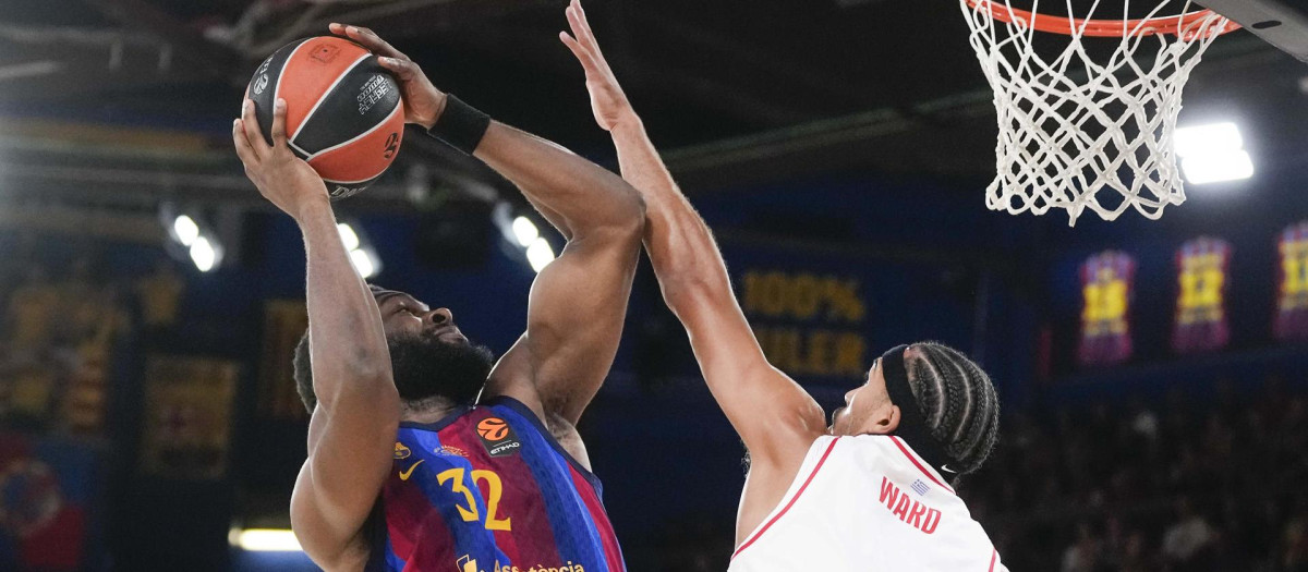 Josh Nebo (i), intenta superar la defensa del jugador estadounidense de Olympiacos, Tyson Ward,
