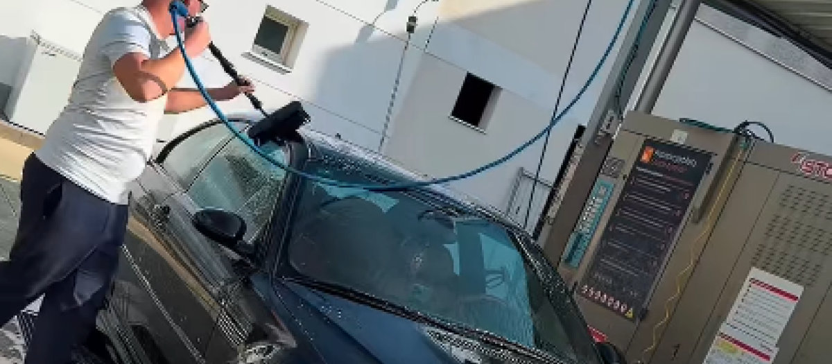 El propietario junto a su BMW en el lavadero