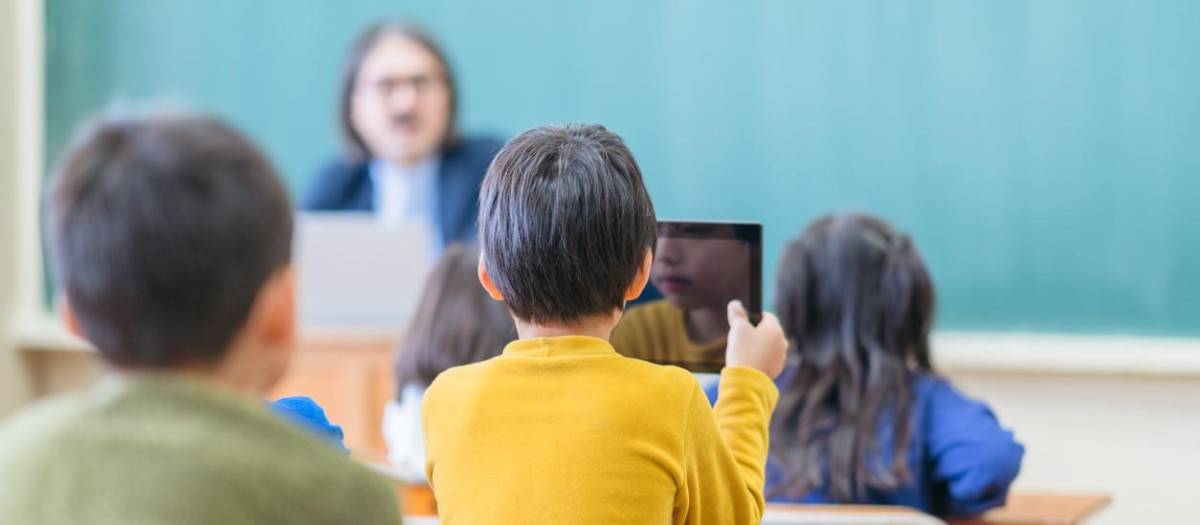 Un grupo de niños en una clase, uno de ellos con una tablet