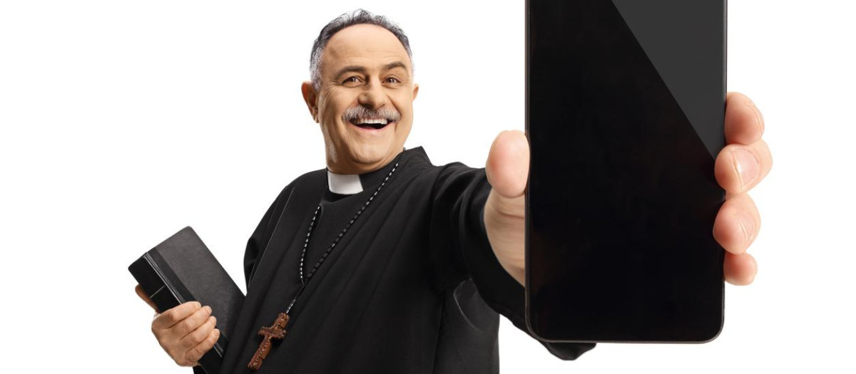 Priest showing a smartphone and holding a bible isolated on white background