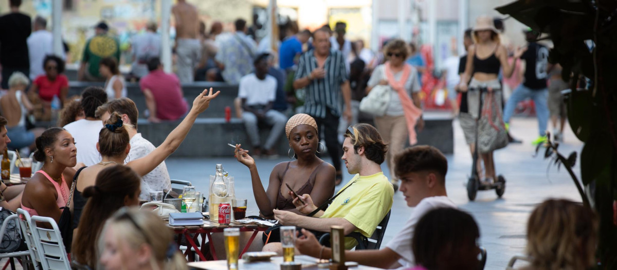 Varias personas sentadas en bares en la plaza dels Àngels del Raval, en Barcelona