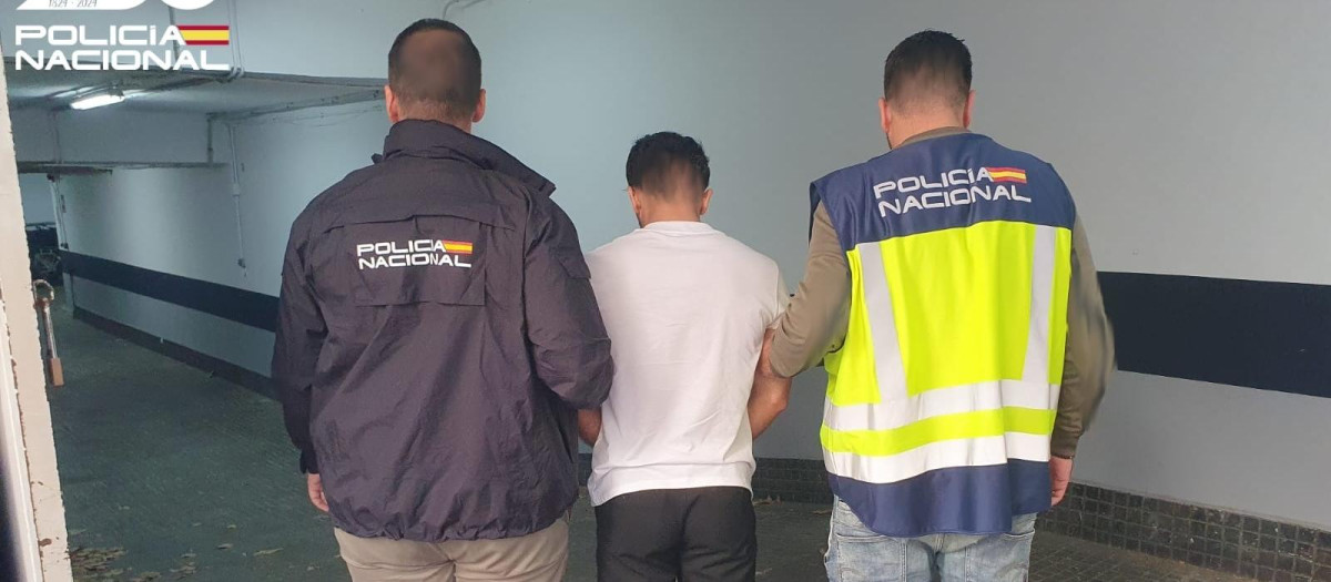 El detenido por robar relojes de lujo a turistas, escoltado por dos agentes de la Policía Nacional.