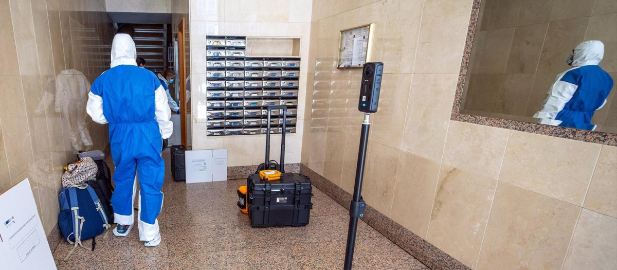 Una agente de la Policía Científica, en el portal de la vivienda donde una anciana resultó muerta durante un robo