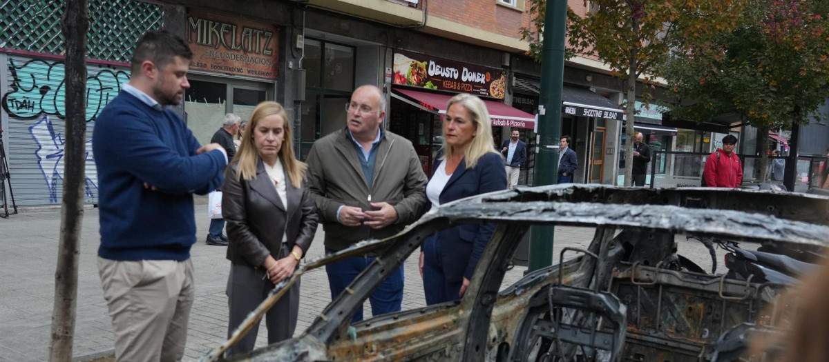 Miguel Tellado junto a uno de los coches calcinados en Bilbao