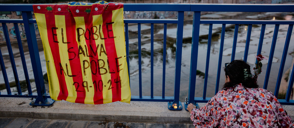 Una persona encendiendo velas durante una marcha en el homenaje a las víctimas de la dana