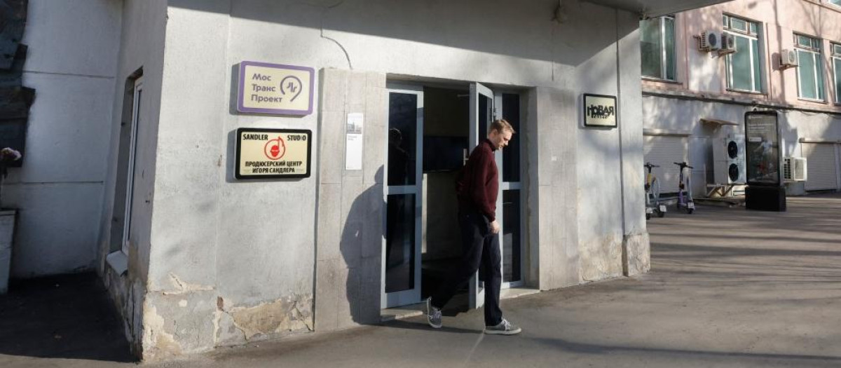 A man leaves a building housing the editorial office of the independent media outlet Novaya Gazeta, as a plaque commemorating of slain anti-Kremlin Russian reporter Anna Politkovskaya is seen on the wall (L), in Moscow on October 30, 2026. Russia's flagship independent newspaper Novaya Gazeta announced on October 30, 2026 it was closing, saying it had been "killed" by state pressure after years of repression targeting its journalists whose reporting was critical of the Kremlin and its Ukraine war. (Photo by TATYANA MAKEYEVA / AFP)