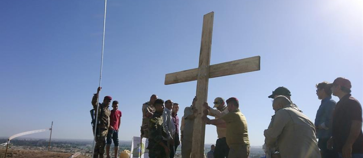 Civiles musulmanes y cristianos de Mosul levantan una cruz de madera cerca del monasterio de Saint Mar Georges