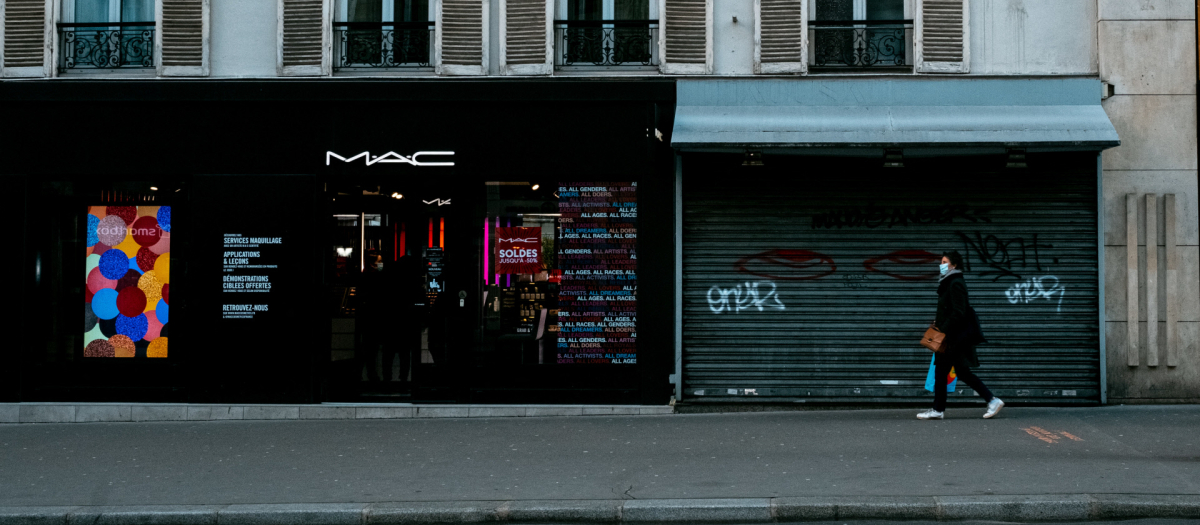 Una mujer camina por la calle delante de un negocio cerrado