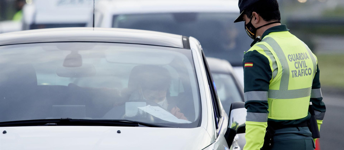 Un agente de la Guardia Civil le pide la documentación al conductor de un vehículo durante un control