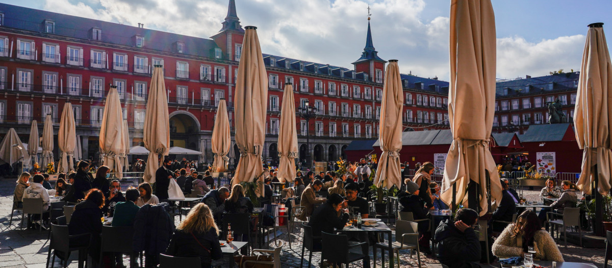 Varias personas consumen en la Plaza Mayor de Madrid