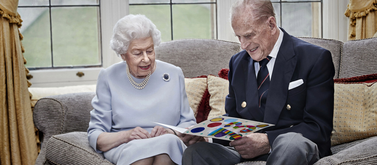 In this image released on Thursday Nov. 19, 2020, Britain's Queen Elizabeth II and Prince Philip, Duke of Edinburgh look at a homemade wedding anniversary card,England, Nov. 17, 2020,