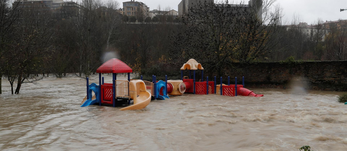 Un parque infantil inundado por el desbordamiento del río Arga a su paso por el barrio de la Rochapea en Pamplona, este viernes. Los ríos Arga, Ega, Larraun, Ezkurra, Urederra y Baztán han alcanzado en las últimas horas el nivel de alerta por inundaciones en Navarra, donde han comenzado a producirse incidencias en diversas zonas con calles y garajes anegados y carreteras cortadas.