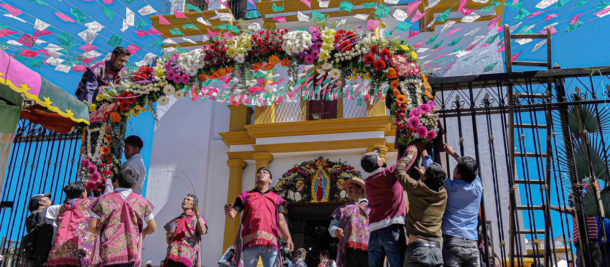 Indígenas organizan la decoración de una portada con flores a la Virgen de Guadalupe (México)