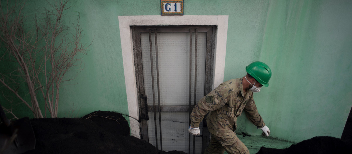 Un miembro del Ejército español retira las cenizas de las casas cubiertas de lava tras la erupción del volcán Cumbre Vieja, en Las Manchas, en la isla canaria de La Palma el 14 de diciembre de 2021