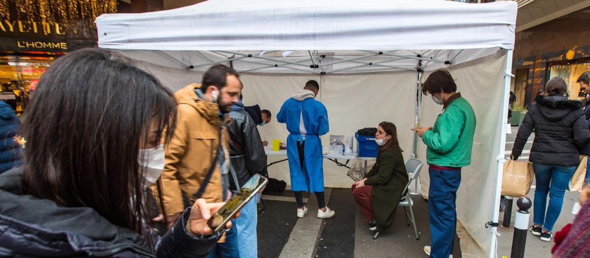 Un grupo de personas espera para someterse a un test covid en una tienda instalada frente a las famosas galerías Lafayette de París