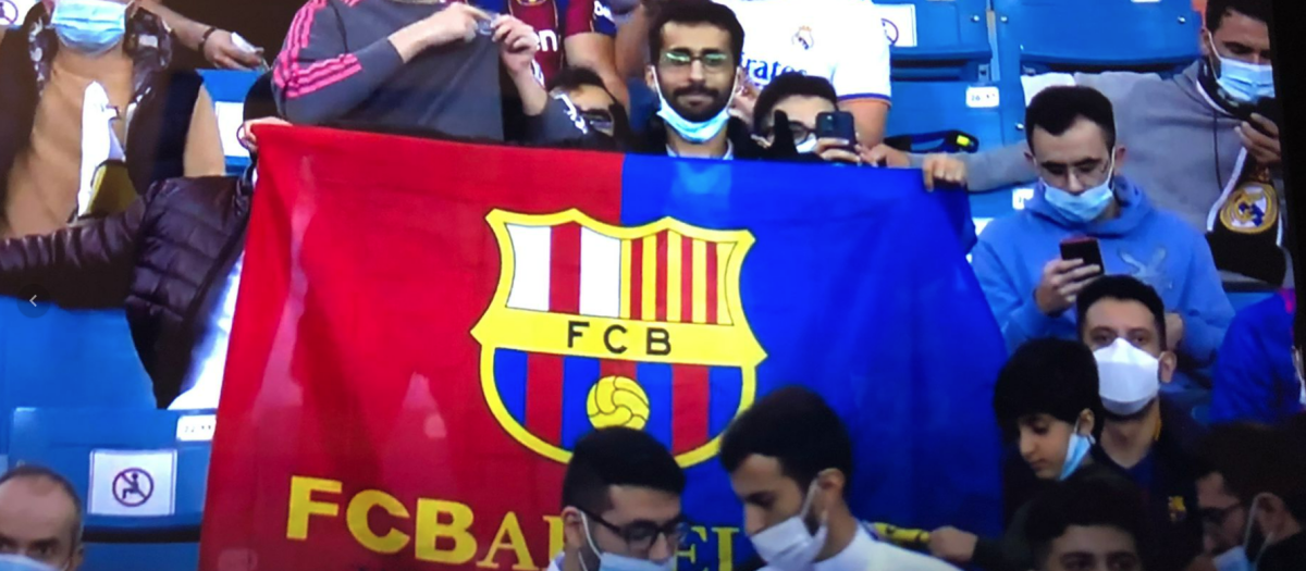 Un fanático del Barça levanta una bandera de su equipo en el que se ha borrado la cruz del escudo