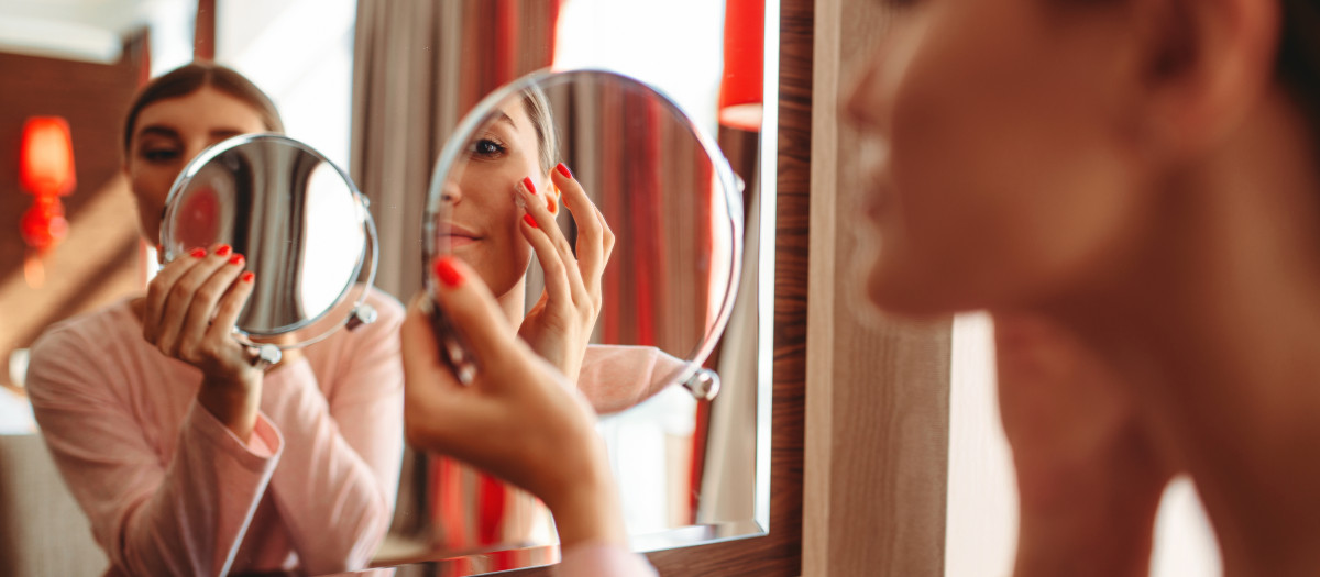 Young woman doing makeup in front of the mirror in the bedroom. Female person cares for skin. Morning face hygiene.the,doing,makeup,mirror,face,hygiene,in,morning, mirror, bedroom, pierglass, beauty, female, indoor, woman, beautiful, looking, face, young, brush, attractive, reflection, home, care, skin, pretty, girl, person, wash, white, happy, smile, routine, people, caucasian, acne, lifestyle, treatment, one, makeup, portrait, healthy, natural, health, hygiene, cosmetics, clean, up, pajama, fresh, touching, body, skincare, freshness, pampering, lady