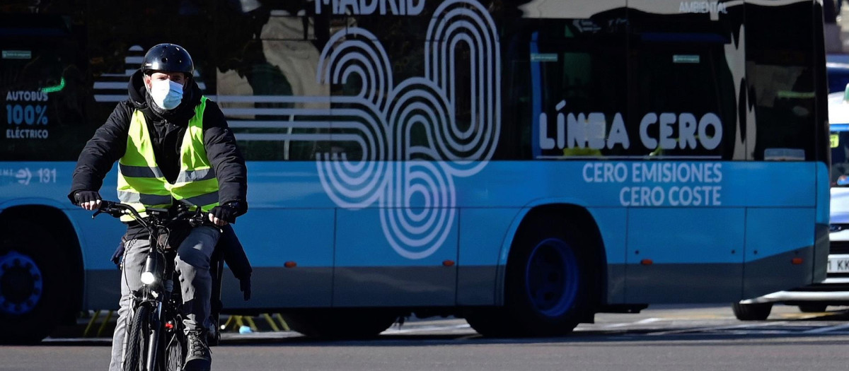 Un ciclista pasa junto a un autobús, en Madrid, a mediados de enero