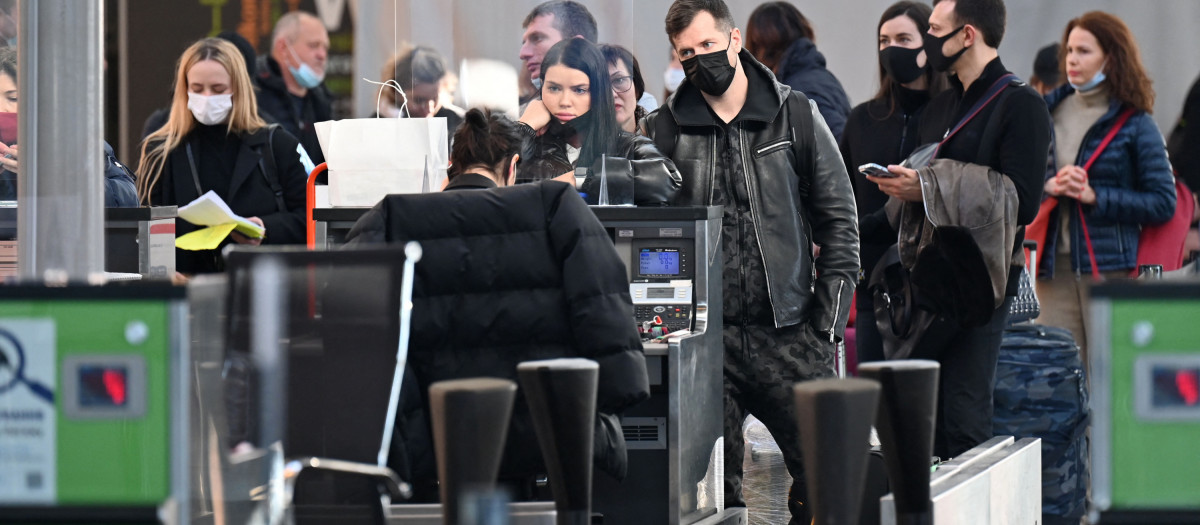 Travellers wait at the check-in counters ahead of their flights at the Boryspil airport some 30 kilimetres outside Kyiv on February 13, 2022. - Ukraine on February 13, 2022, vowed to keep its airspace open to international travel despite Western warnings that Russian troops conducting drills near its borders could invade at any point. (Photo by Sergei Supinsky / AFP)