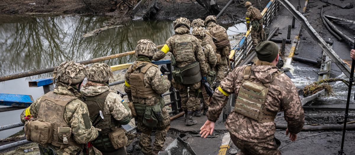 Soldados ucranianos observando la destrucción de un puente en Irpin.